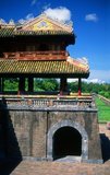 The Ngọ Môn (Chinese character: 午門), also known as the Gate of Noon, is the main gate to the Imperial City, Huế, located within the citadel of Huế. It was built in 1833 in the traditional Vietnamese Nguyen style under the rule of Emperor Minh Mang.<br/><br/>Emperor Gia Long ordered the construction of Hue Citadel in 1805. The vast complex is built according to the notions of fengshui or Chinese geomancy, but following the military principles of the noted 18th century French military architect Sebastien de Vauban. The result is an unusual and elegant hybrid, a Chinese-style Imperial City carefully aligned with surrounding hills, islands and waterways, but defended by massive brick walls between 6-12 metres high and 2.5 metres thick, punctuated by towers, ramparts, a massive earth glacis, and 24 Vauban-inspired bastions.<br/><br/>The entire complex was further protected by wide moats, crossed by gracefully arched stone bridges leading to ten gates, the chief of which is Cua Ngo Mon, the south-east facing ‘Meridian Gate’. To compound the exotic hybrid effect, guard posts designed as Chinese-style miradors, complete with sweeping eaves crowned by imperial dragons, surmounted each gate. Finally, directly in front of the Ngo Mon Gate, a massive brick fort 18 metres high was constructed both as an additional barrier against malign spirits, and as a defensive redoubt.<br/><br/>The area within the Citadel - in all, 520 hectares (1300 acres) - comprises three concentric enclosures, the Civic, Imperial and Forbidden Purple Cities. Access is by way of ten fortified gates, each of which is reached by a low, arched stone bridge across the moat. In imperial times a cannon would sound at 5am and 9pm to mark the opening and closing of the gates.<br/><br/>Hue was the imperial capital of the Nguyen Dynasty between 1802 and 1945. The tombs of several emperors lie in and around the city and along the Perfume River. Hue is a UNESCO World Heritage Site.