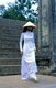 Vietnam: A student in a traditional Vietnamese <i>ao dai</i> ('long dress') and <i>non la</i> (conical hat) at the Thien Mu (Thiên Mụ) Pagoda, Hue