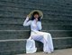 The ao dai (Vietnamese: áo dài) is a Vietnamese national costume, now most commonly for women. In its current form, it is a tight-fitting silk tunic worn over pantaloons. The word is pronounced ow-zye in the north and ow-yai in the south, and translates as 'long dress'.<br/><br/>The name áo dài was originally applied to the dress worn at the court of the Nguyễn Lords at Huế in the 18th century. This outfit evolved into the áo ngũ thân, a five-paneled aristocratic gown worn in the 19th and early 20th centuries. Inspired by Paris fashions, Nguyễn Cát Tường and other artists associated with Hanoi University redesigned the ngũ thân as a modern dress in the 1920s and 1930s.